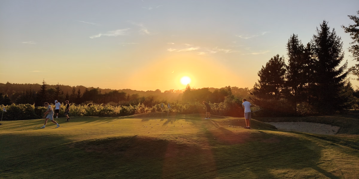 Group playing on the golf course at sunset