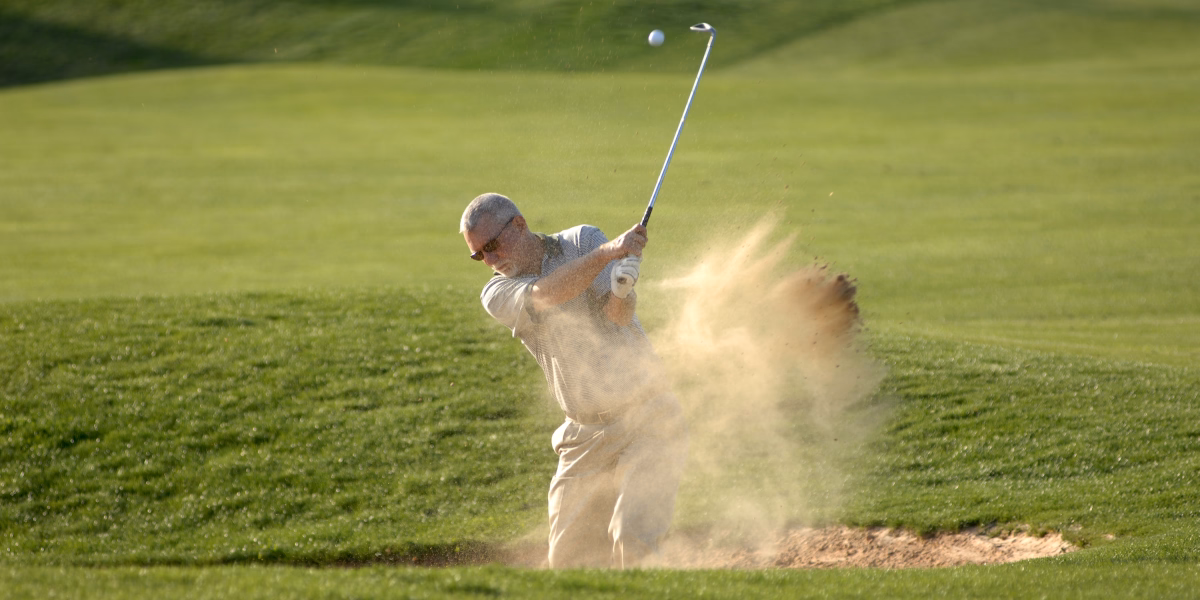 Golfista uderza z bunkra na fairwayu